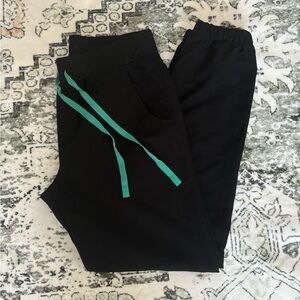Figs black jogger pants with green tie.